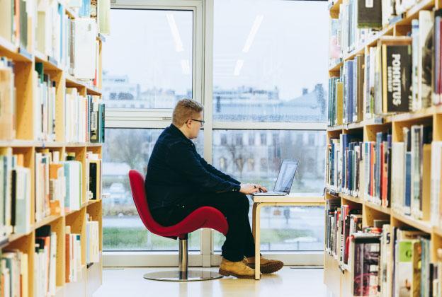 Man working remotely in a library.